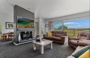 a living room with a couch and a fireplace at Tauranga Luxury Getaway in Tauranga
