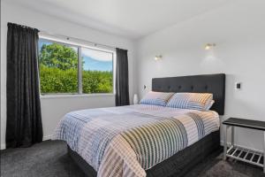 a bedroom with a bed and a window at Tauranga Luxury Getaway in Tauranga