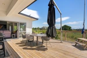 a patio with a table and an umbrella at Tauranga Luxury Getaway in Tauranga