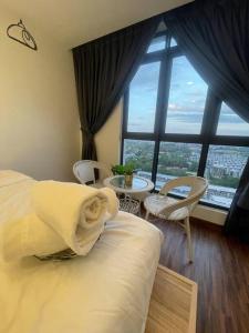 um quarto com uma cama e cadeiras e uma grande janela em K Avenue Cozy Family Suites 4-6 pax 亚庇国际机场5分钟 em Donggongon