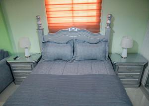 Suite in San Pedro De Macoris في سان بيدرو دي ماكوريس: غرفة نوم بسرير كبير مع مواقف ليلتين