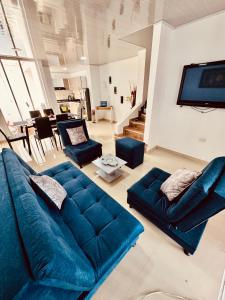 ein Wohnzimmer mit einem blauen Sofa und einem TV in der Unterkunft Casa de Descanso Excelente Ubicación Villavicencio in Villavicencio