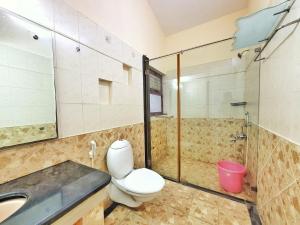 a bathroom with a toilet and a sink and a shower at Park Breeze Penthouse in Bangalore
