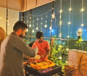 a man holding a plate of food on a table at Park Breeze Penthouse in Bangalore