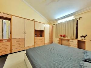 a bedroom with a large bed and wooden cabinets at Park Breeze Penthouse in Bangalore