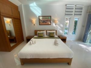 ein Schlafzimmer mit einem großen weißen Bett in einem Zimmer in der Unterkunft Chang Noi Hua Hin Pranburi fully accessible barrierefrei resort in Ban Nong Sua