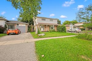 una casa con un perro sentado en el patio en Cozy Lower Level 2BR Apartment, en Barrie