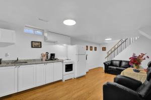 een keuken met witte kasten en een woonkamer bij Cozy Lower Level 2BR Apartment in Barrie