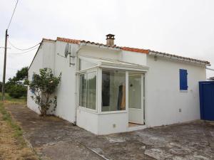 une petite maison blanche avec une grande porte en verre dans l'établissement Maison rénovée 3 pièces, proche centre historique, calme, 6 couchages - FR-1-246A-288, à Saint-Georges-dʼOléron