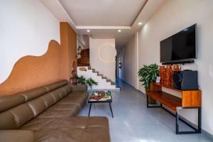 a living room with a couch and a flat screen tv at Mayy House Dalat in Da Lat