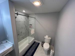 uma casa de banho com um chuveiro, um WC e um lavatório. em The Homey Suite - 1BR with Luxe Amenities em Paterson