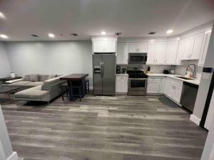 uma cozinha com armários brancos, uma mesa e um sofá em The Homey Suite - 1BR with Luxe Amenities em Paterson