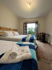 a bedroom with two beds with towels on them at Villa Rural in Campos do Jordão