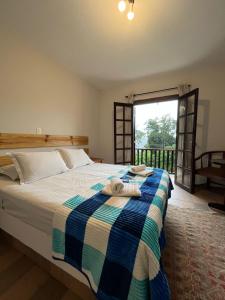 1 dormitorio con 1 cama con manta azul y blanca en Villa Rural, en Campos do Jordão