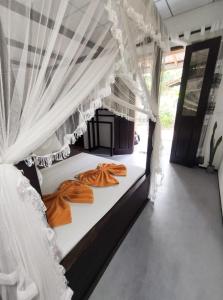 AURORA Midigama في آهانغاما: سرير في غرفة مع ستائر بيضاء