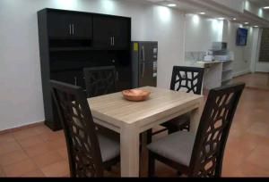 kuchnia z drewnianym stołem i krzesłami z miską w obiekcie Relax sin ruidos centrico. w mieście Santa Rosa de Copán