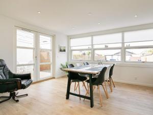 a dining room with a table and chairs and windows at 4 person holiday home in Skagen in Skagen