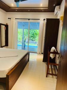 a bedroom with a bed and a sliding glass door at SuSha Happy Three Villa in Hikkaduwa