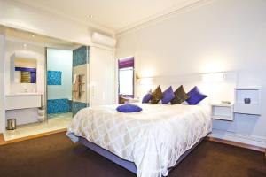 a large bedroom with a large bed with blue pillows at The Retreat at Froog Moore Park in Tamworth