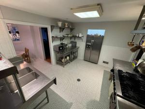 a kitchen with a stainless steel refrigerator in a room at Serene Stay - Stylish House Close to NYC in Paterson +39 photos
