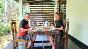 un hombre y una mujer sentados en una mesa con comida en Yashi's Place Sigiriya en Sigiriya