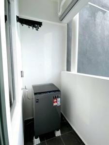 Un baño pequeño con un cubo de basura en la esquina en JOVIAL Modern Cozy Suite `Metropol BM BandarPerda, en Bukit Mertajam