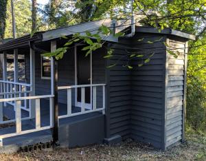 una casetta minuscola con un portico nel bosco di Loblolly Pines Adventure Cabin 4 King a Eureka Springs