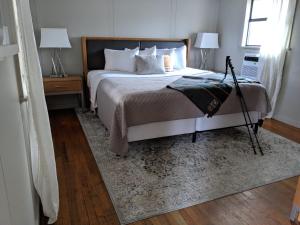 a bedroom with a bed with two lamps and a rug at Loblolly Pines Adventure Cabin 4 King in Eureka Springs