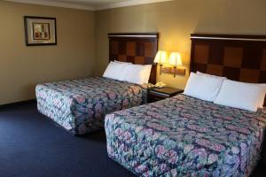 a hotel room with two beds and two lamps at Inn at Bayshore in San Mateo +3 photos