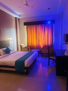 a hotel room with a bed and a window with lights at Hotel Excalibur in Kottayam