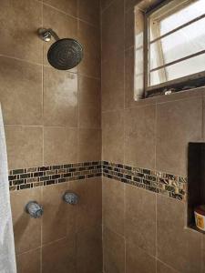 La salle de bains est pourvue d'une douche et d'une fenêtre. dans l'établissement Encantadora casa con ubicación privilegiada, à Monterrey