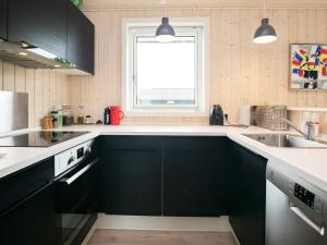 a kitchen with black cabinets and a window at 5 person holiday home in Haarby in Brunshuse