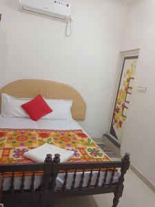 - une chambre avec un lit et un oreiller rouge dans l'établissement Hilton Beach Home, à Alappuzha