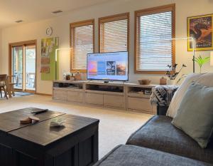 A quiet, stylish and cozy retreat. في بيج: غرفة معيشة مع تلفزيون وأريكة