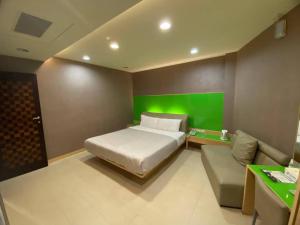 1 dormitorio con cama y pared verde en Love Hotel, en Pingtung City