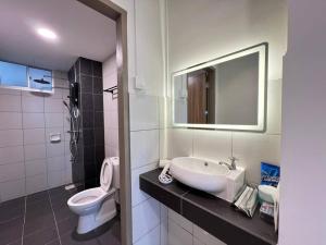 a bathroom with a sink and a toilet and a mirror at AJ Homestay Near Kuching Airport in Kuching +12 photos