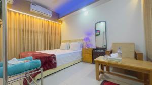 a hotel room with a bed and a mirror at Hotel Blue Sky Mirpur in Dhaka