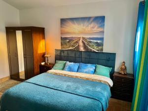 - une chambre dotée d'un lit bleu et d'une peinture murale dans l'établissement Villa Quatro Ventos Benagil, à Lagoa