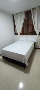 a bed in a room with a white floor at Los Pinos in Jardin