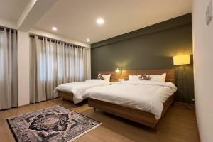 a bedroom with two beds and a large window at 21 Tara Apartments in Kathmandu