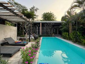 a swimming pool in front of a house at Ren pool villa 清迈3卧泳池别墅 in Chiang Mai