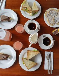 einen Tisch mit Sandwiches und Tassen Kaffee in der Unterkunft Serendib Hotel in Nuwara Eliya