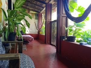 a hallway with plants and a room with a table at The Blues in Alleppey