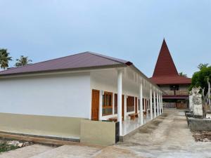 un petit bâtiment blanc avec un toit rouge dans l'établissement Rumah Budaya Sumba, à Lokokaki