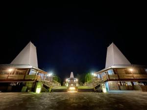 um edifício com duas torres brancas à noite em Rumah Budaya Sumba em Lokokaki