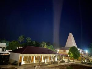 ein Gebäude mit einem Kirchturm in der Nacht in der Unterkunft Rumah Budaya Sumba in Lokokaki