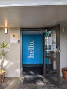 wejście do biura z niebieską ścianą w obiekcie Waiheke Backpackers Hostel w mieście Onetangi