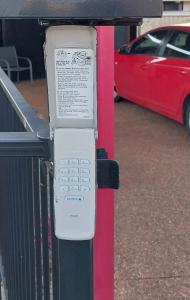 un celular en un poste en un estacionamiento en Red Cottage. 2 ROOM FOR 1. BEDROOM+Private Kithenette, Lounge, TV, Fridge room, en Harristown