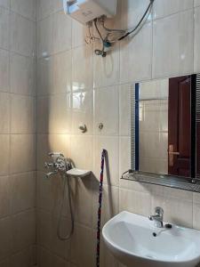 uma casa de banho com um chuveiro, um lavatório e um espelho. em Calm Haven: Your Private Retreat em Kira