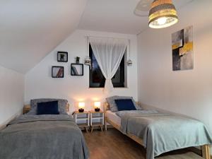 two beds in a room with a window at Chwila Moment - apartament lub cały dom w górach in Stronie Śląskie